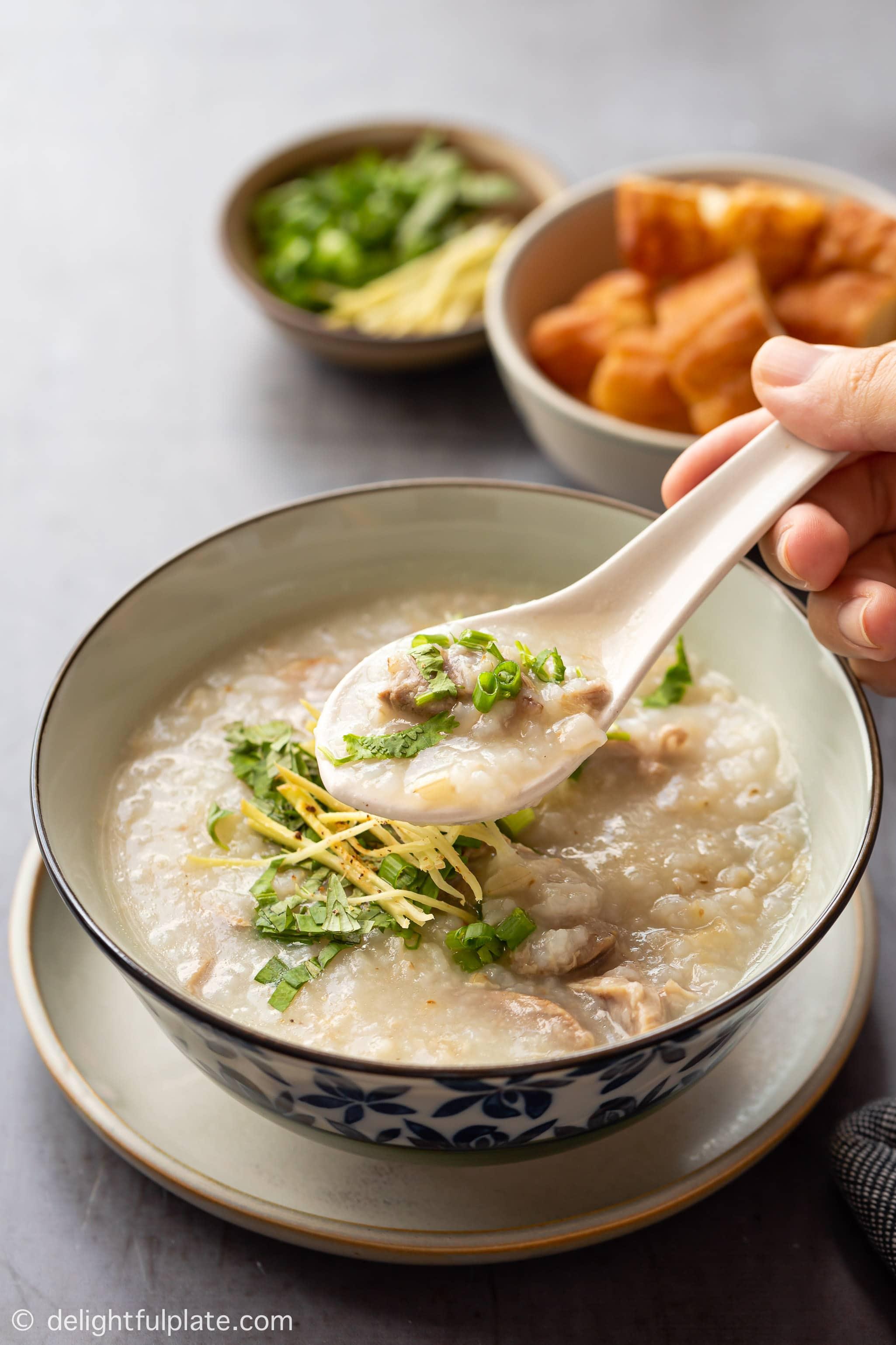 a bowl of duck congee, served with fried dough sticks (youtiao)