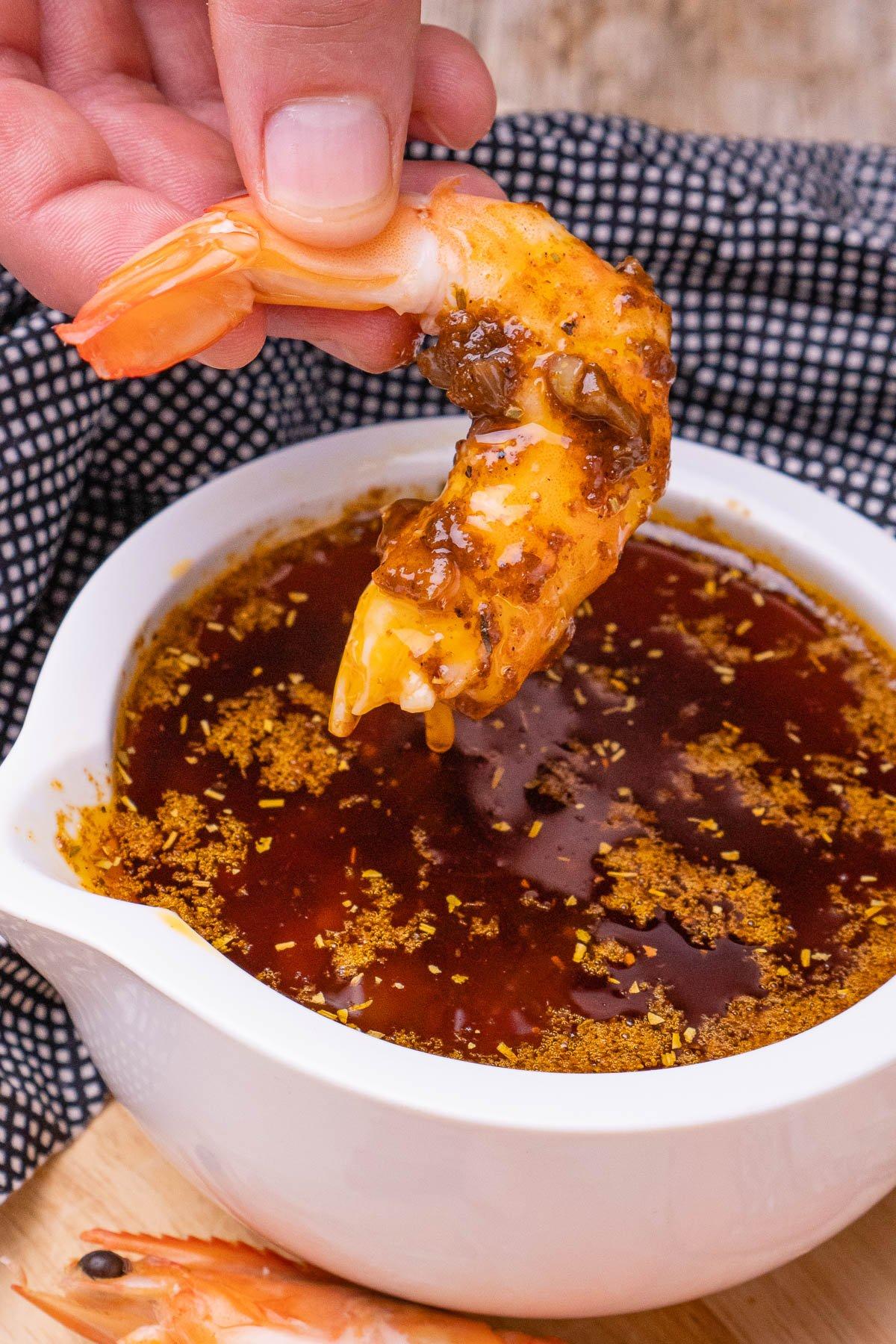 Dipping a prawn into seafood boil sauce