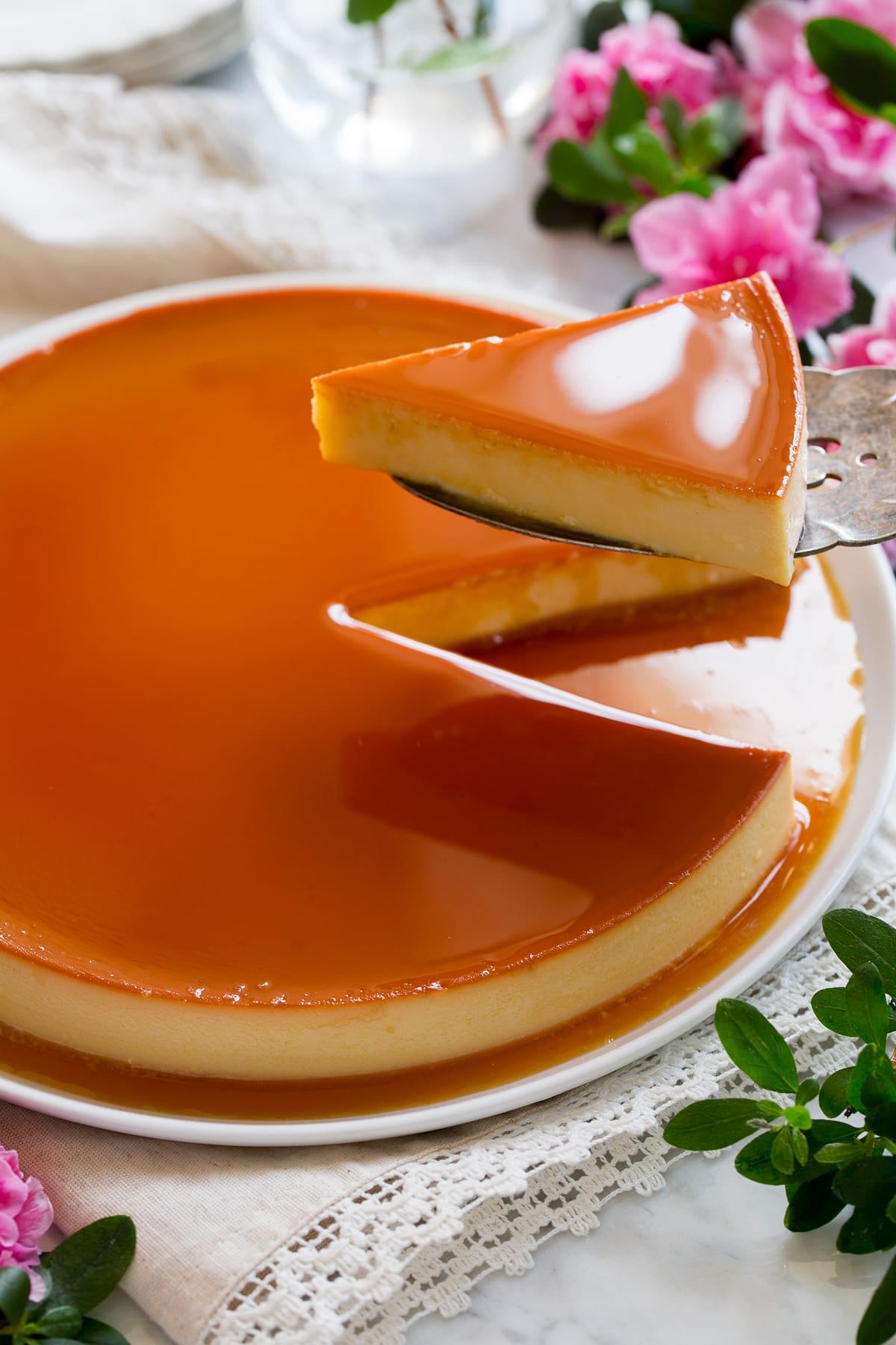 Image showing server spatula removing slice from whole flan.